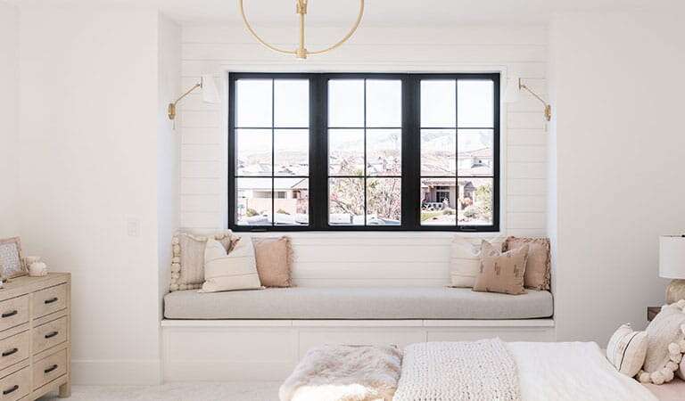 Bedroom window installation with black-framed windows
